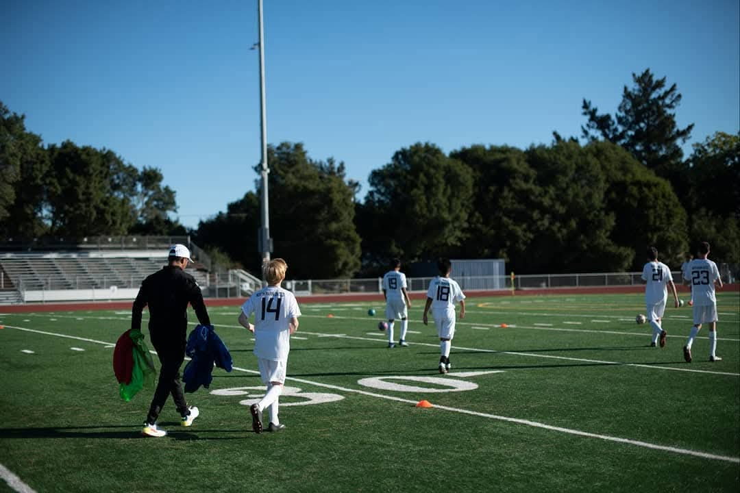 Coach walking with players on the field